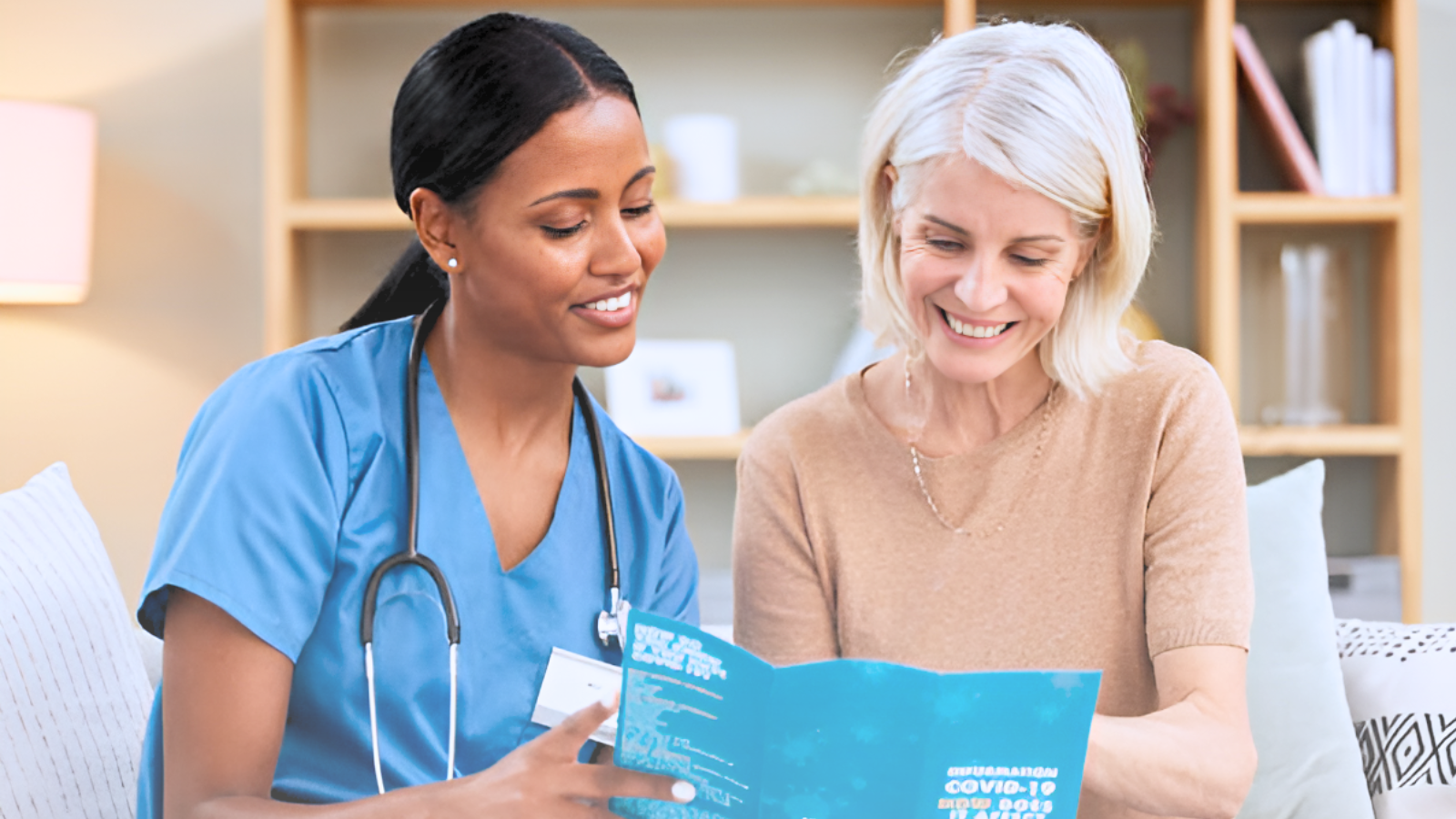A nurse and a patient examine a brochure together, discussing health information in a clinical setting.