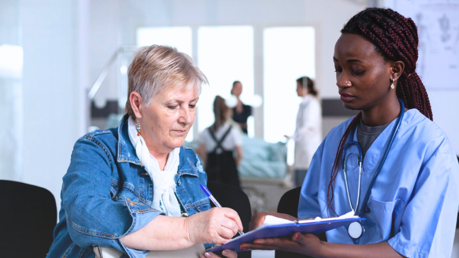 A nurse assists a patient in a hospital room, providing care and support during their recovery.