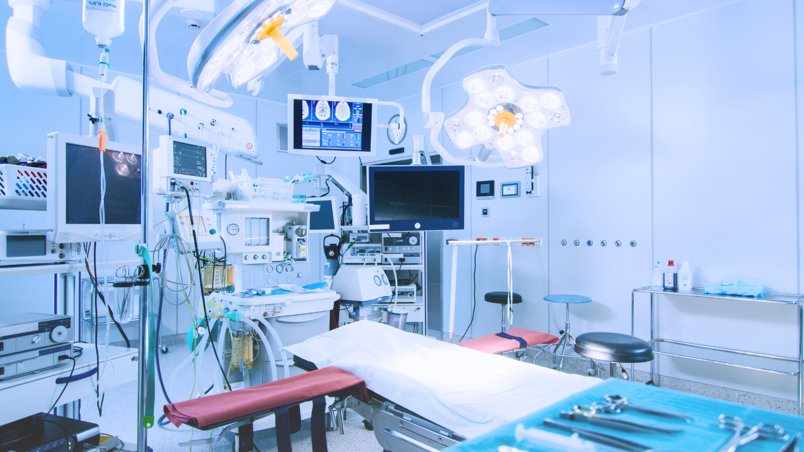 A hospital room featuring medical equipment, including a bed, monitors, and various tools for patient care.